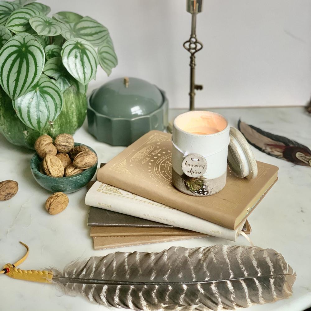 Womens Circle candle, feather, stack of old books