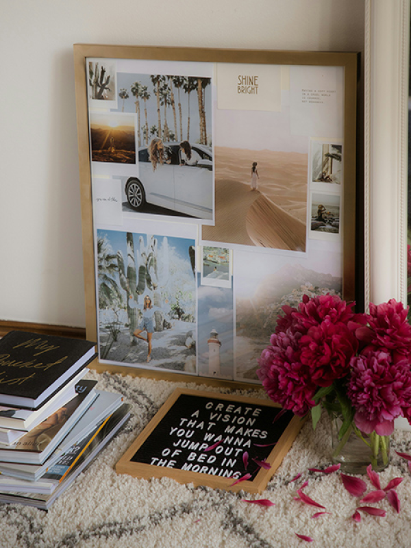 A vision board set on a table with books and flowers