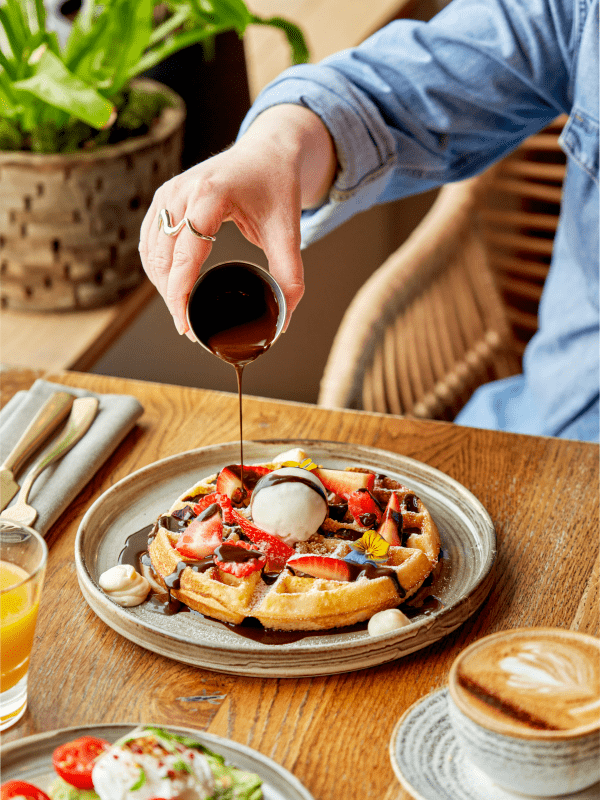 Pouring syrup on waffles