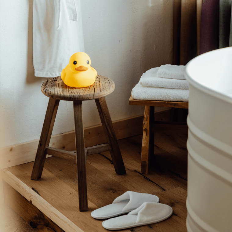 Rubber ducky next to a tub