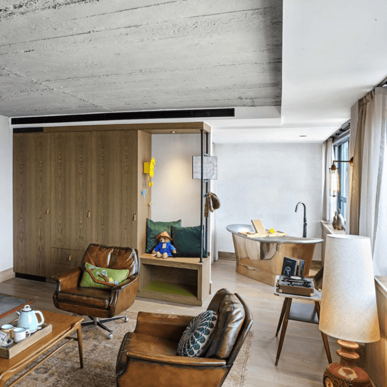 hotel room with king bed, seating area and large wardrobe
