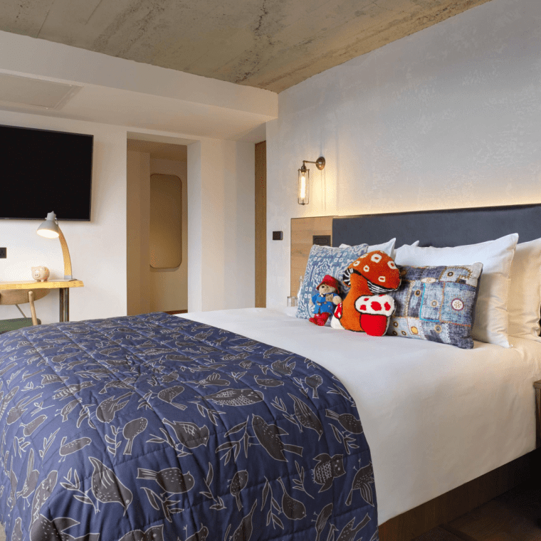hotel room with queen bed and small work desk