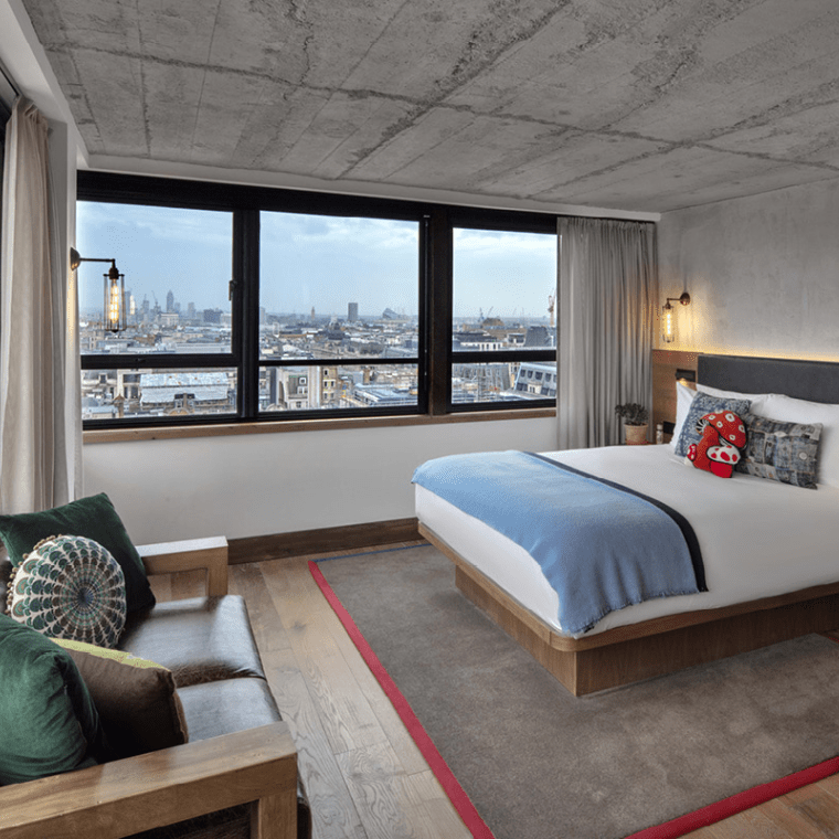 bedroom with queen bed, small seating area and a book case