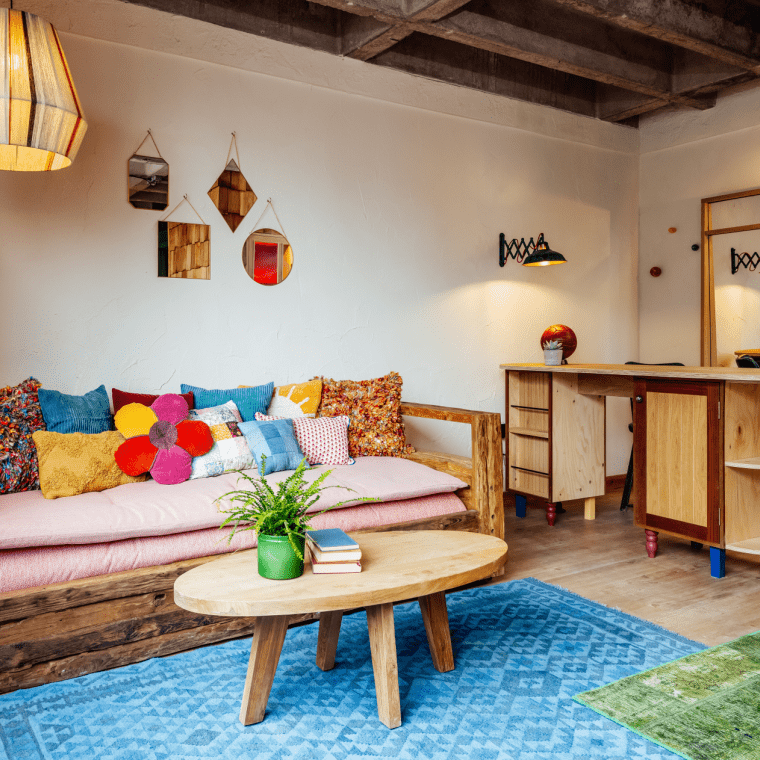 Sofa with various colourful pillows in seating area.