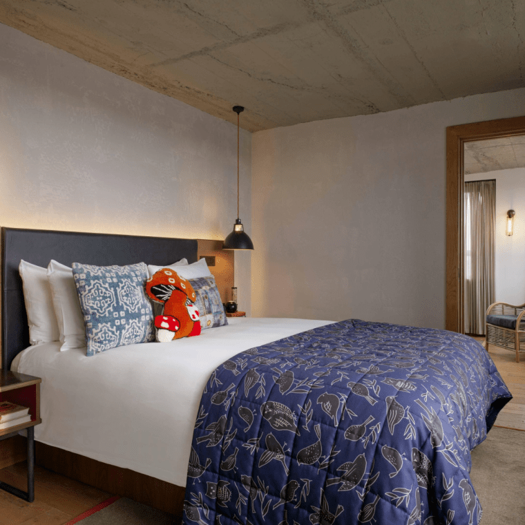 Hotel room with queen bed and view of living area