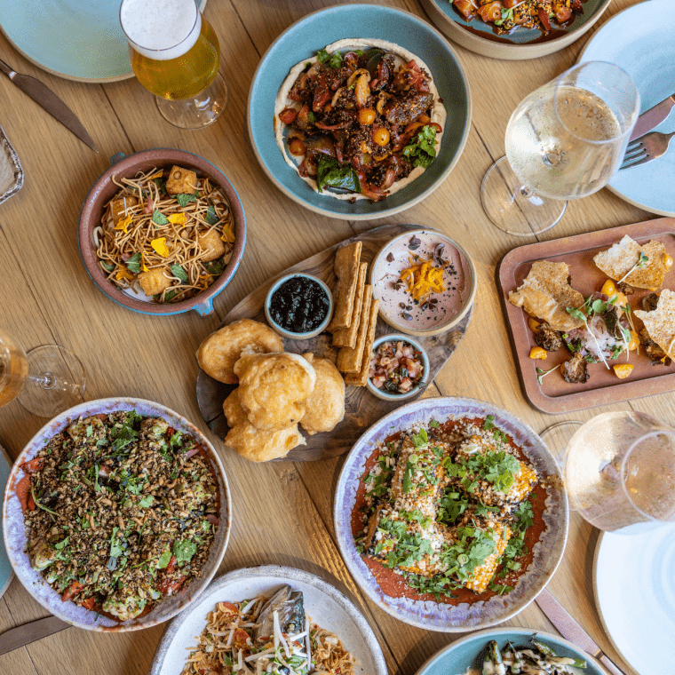 A spread of assorted dishes on a wooden table at Valley Goat restaurant
