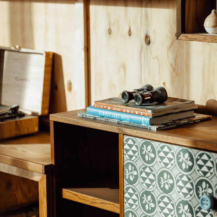wooden storage cabinet with books on top