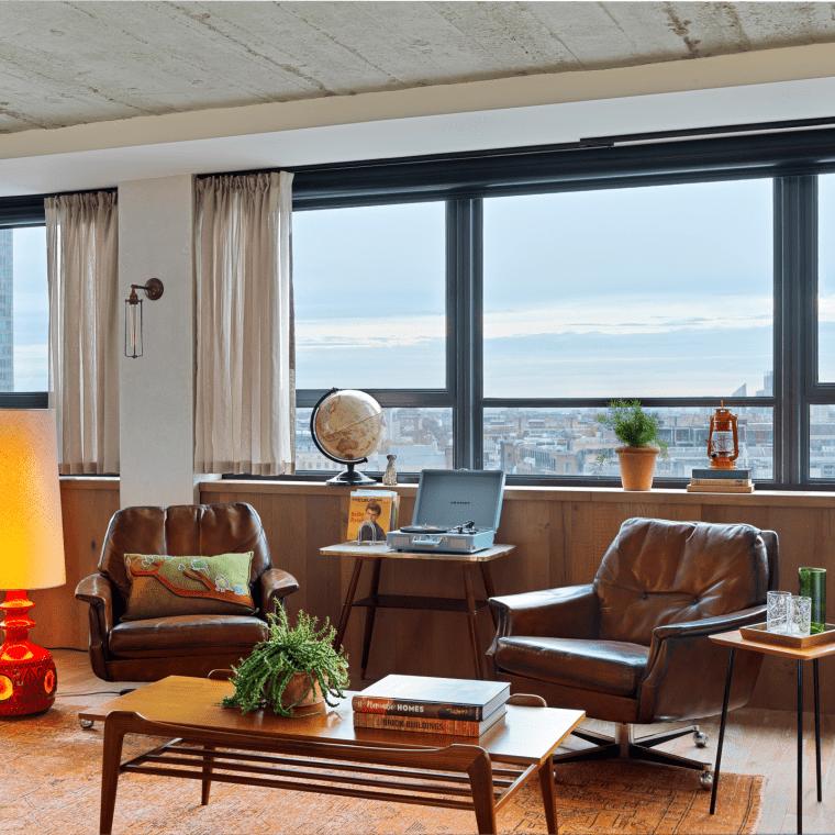 seating area with two leather chairs and wood table