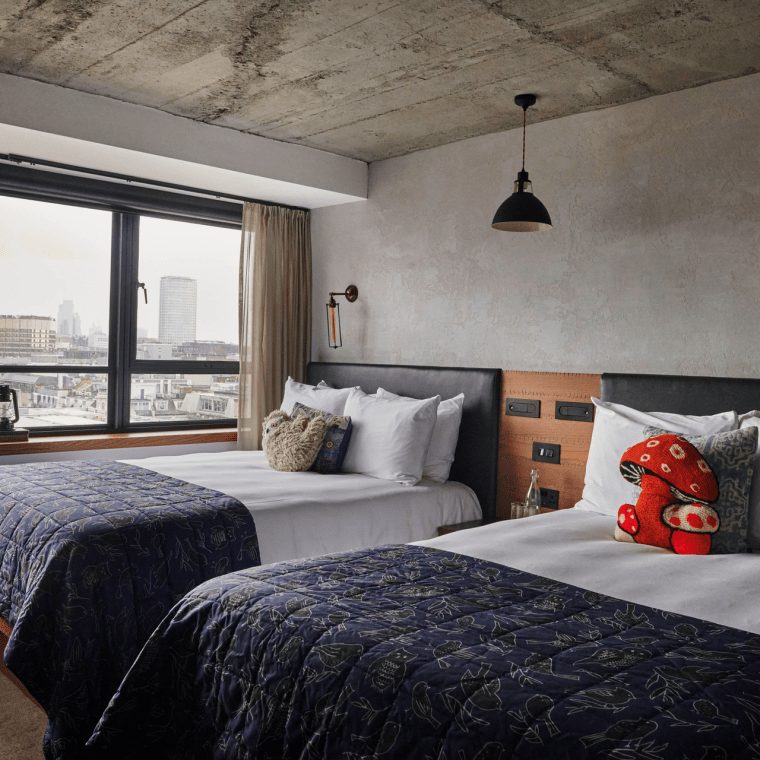 hotel room with two twin beds and view of the city