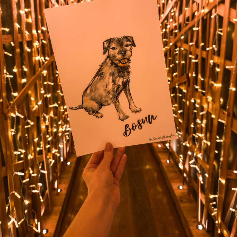 An illustration of a dog held up against the backdrop of The Nest.