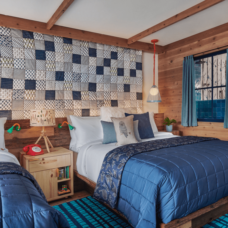 hotel room with two beds and quilted headboard