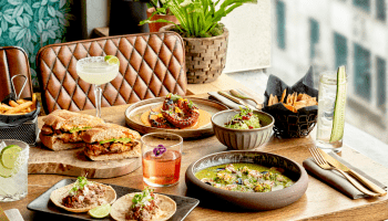 A spread of dinner on a table by a window at Treehouse Hotel.