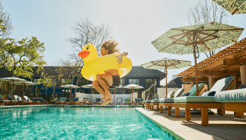 Person jumping into pool with float