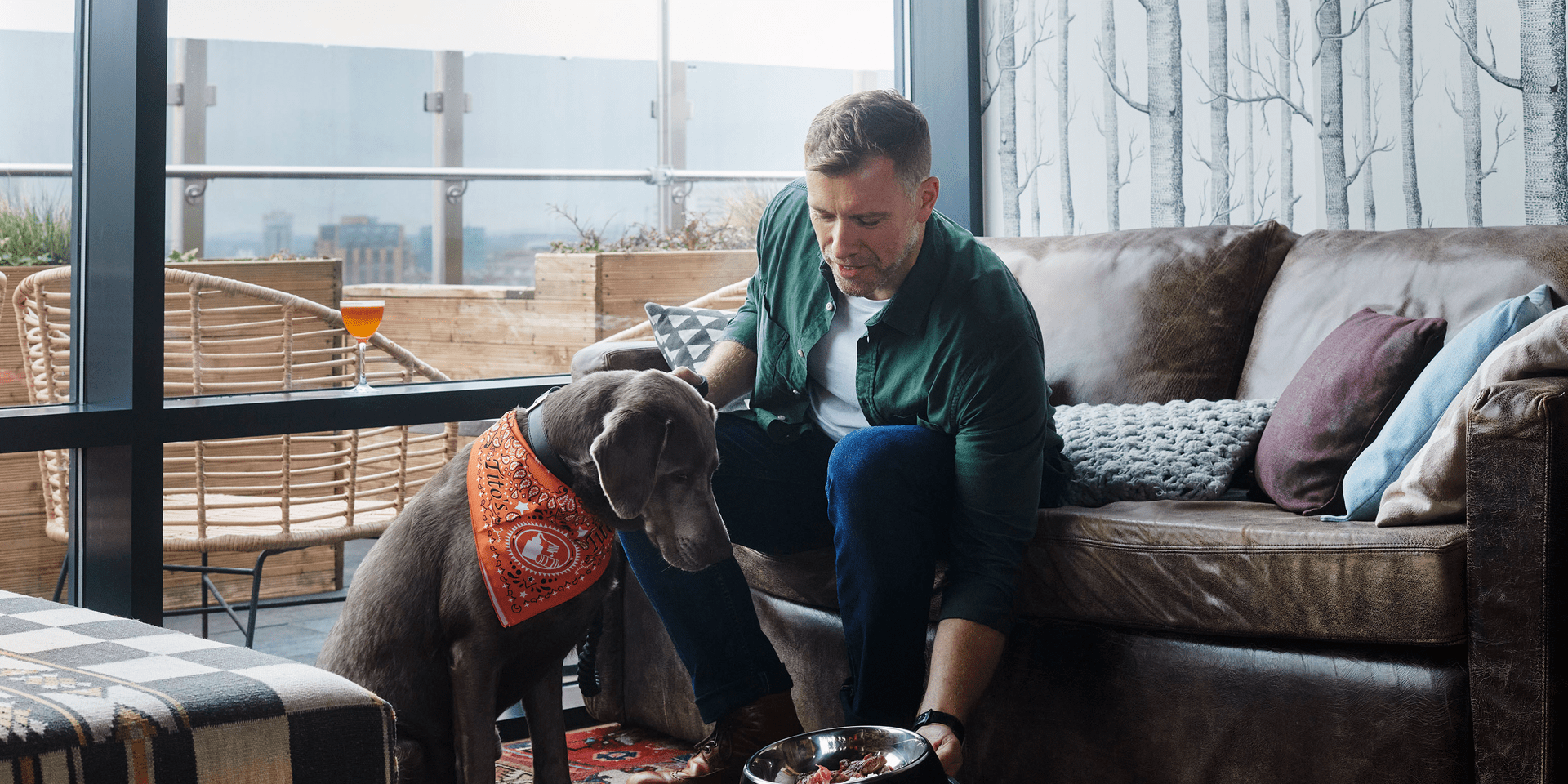 A man giving his dog a bowl of water