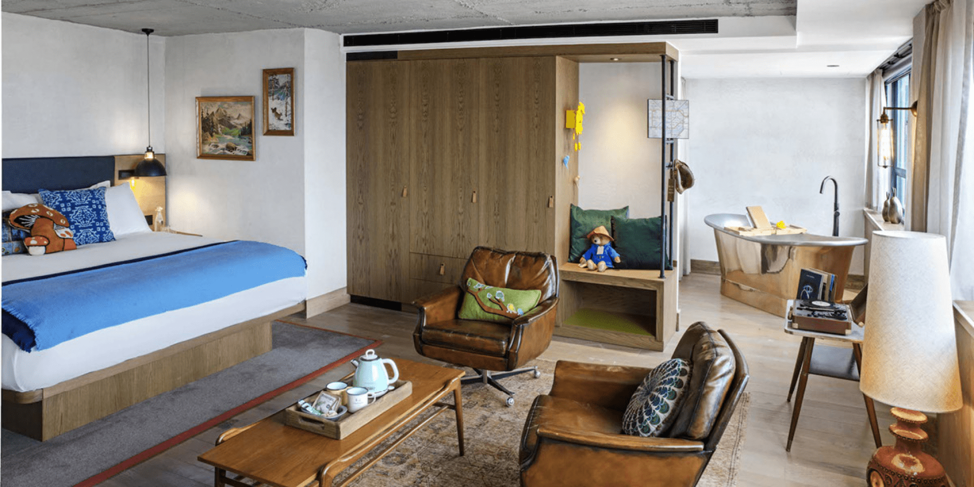 hotel room with king bed, seating area and large wardrobe