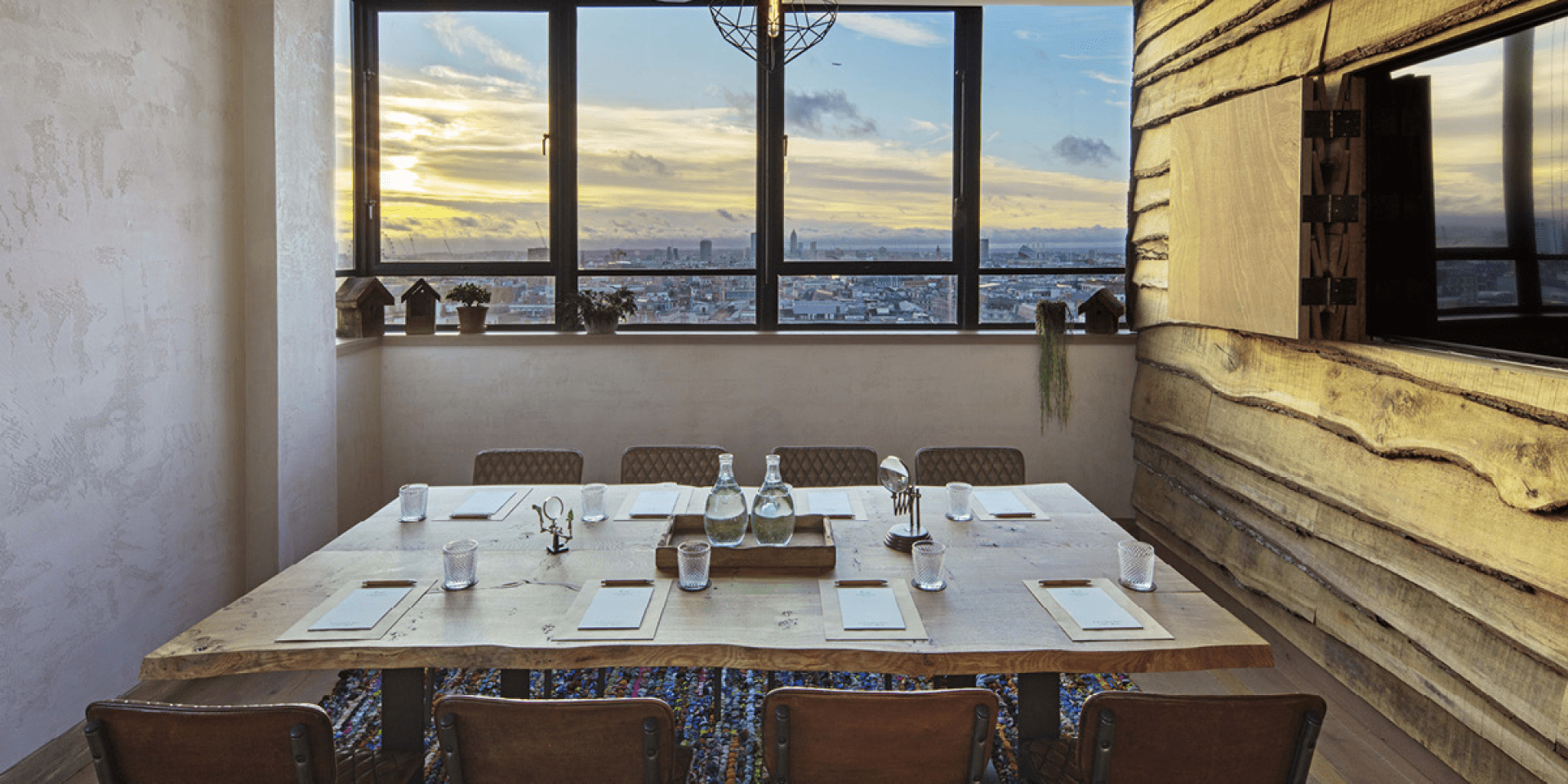 Small meeting room with table set with pads of paper and water