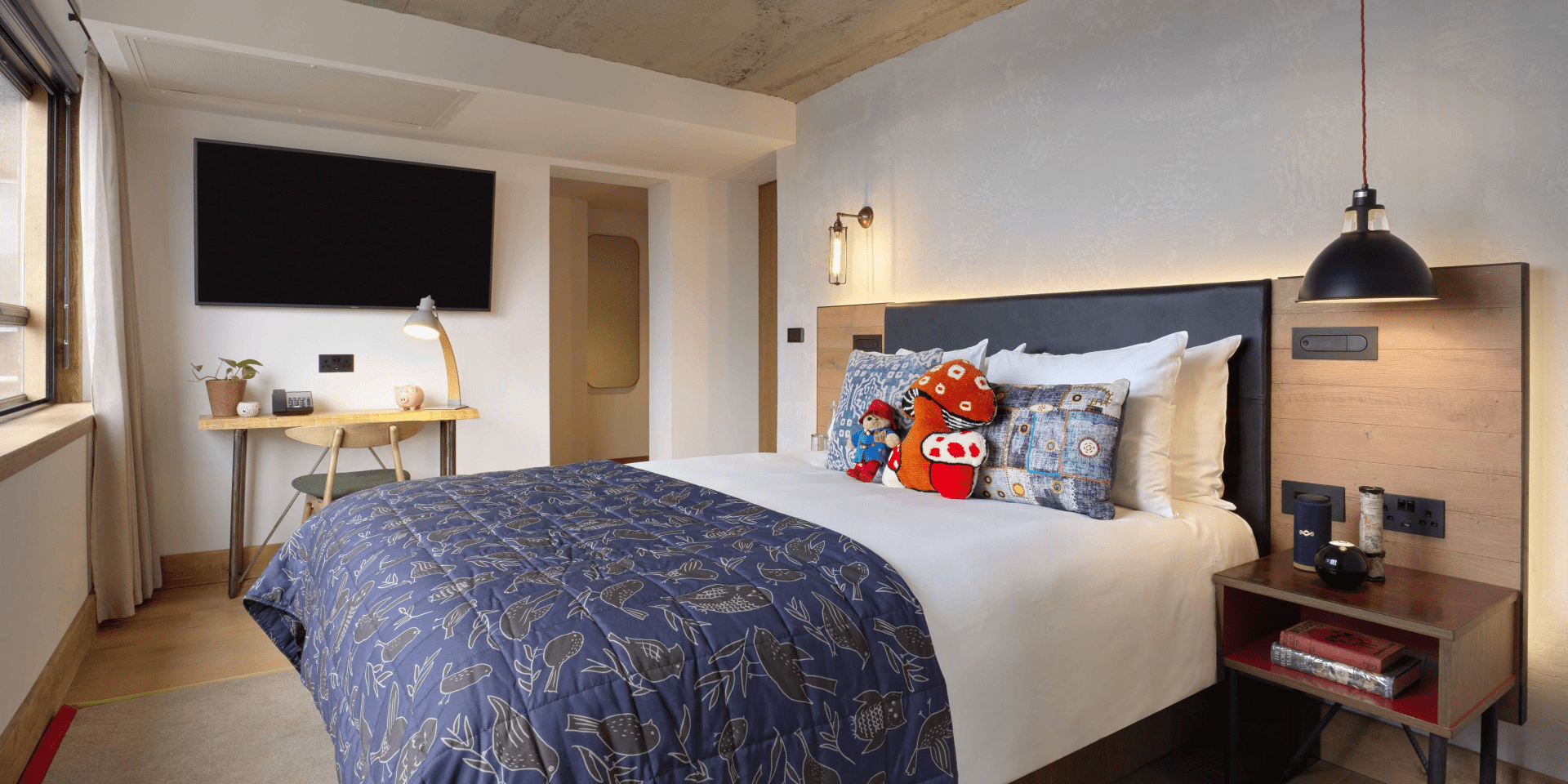 hotel room with queen bed and small work desk