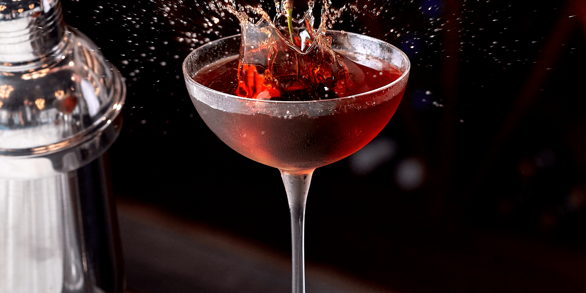The splash of a cherry being dropped into a cocktail