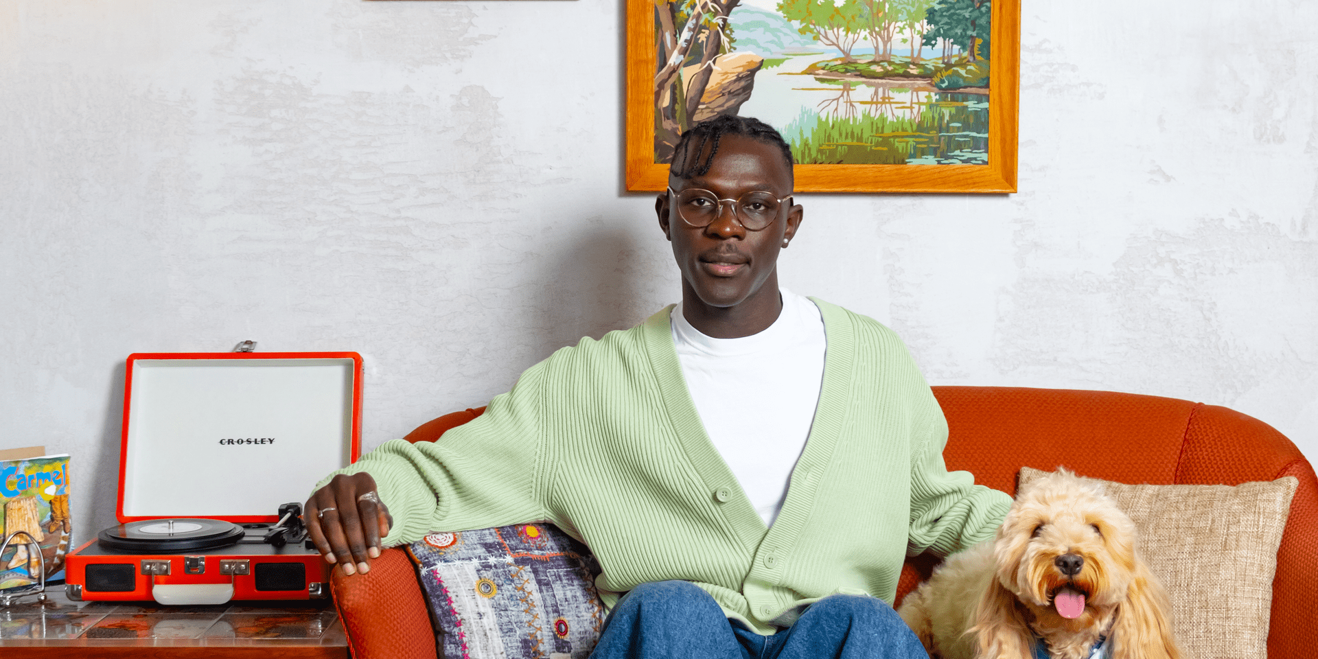 A man sitting on a couch with a dog