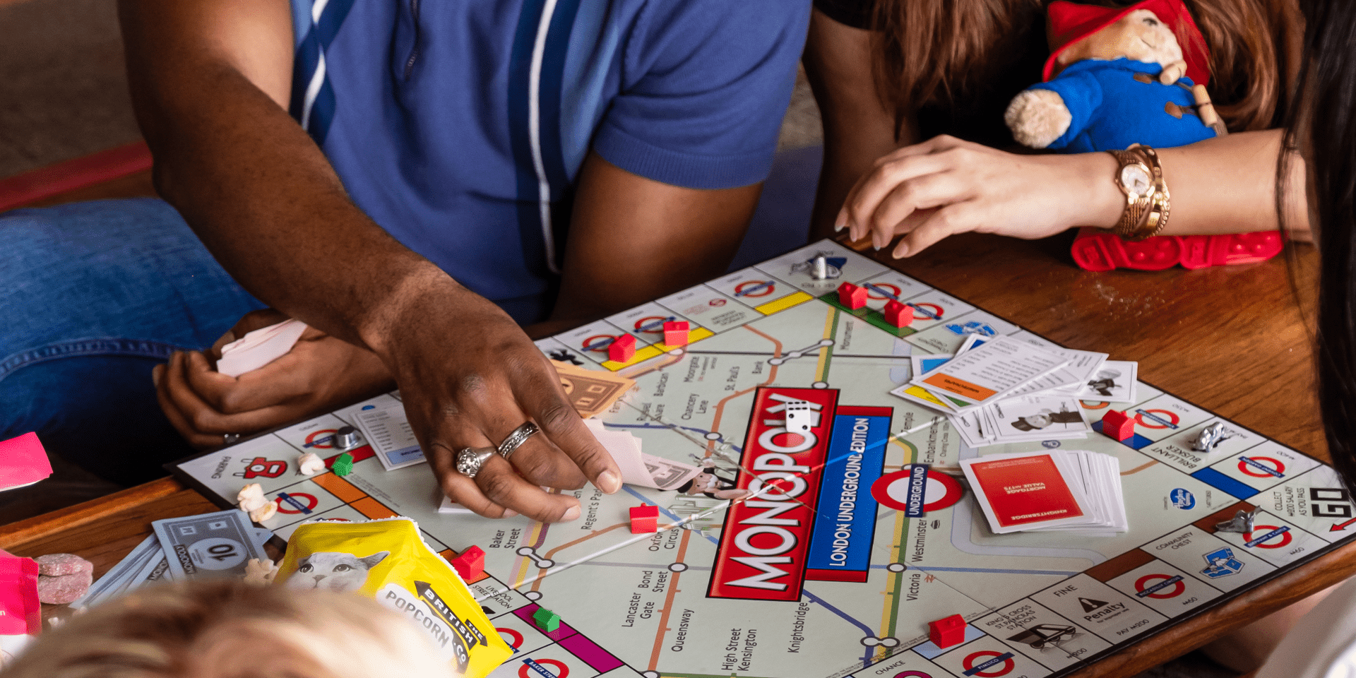 A group of friends playing monopoly the board game.