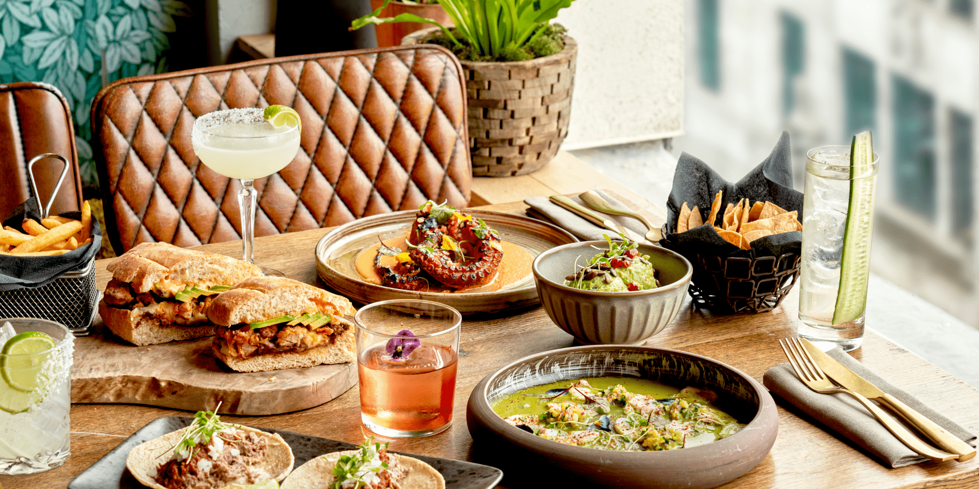 A spread of dinner on a table by a window at Treehouse Hotel.