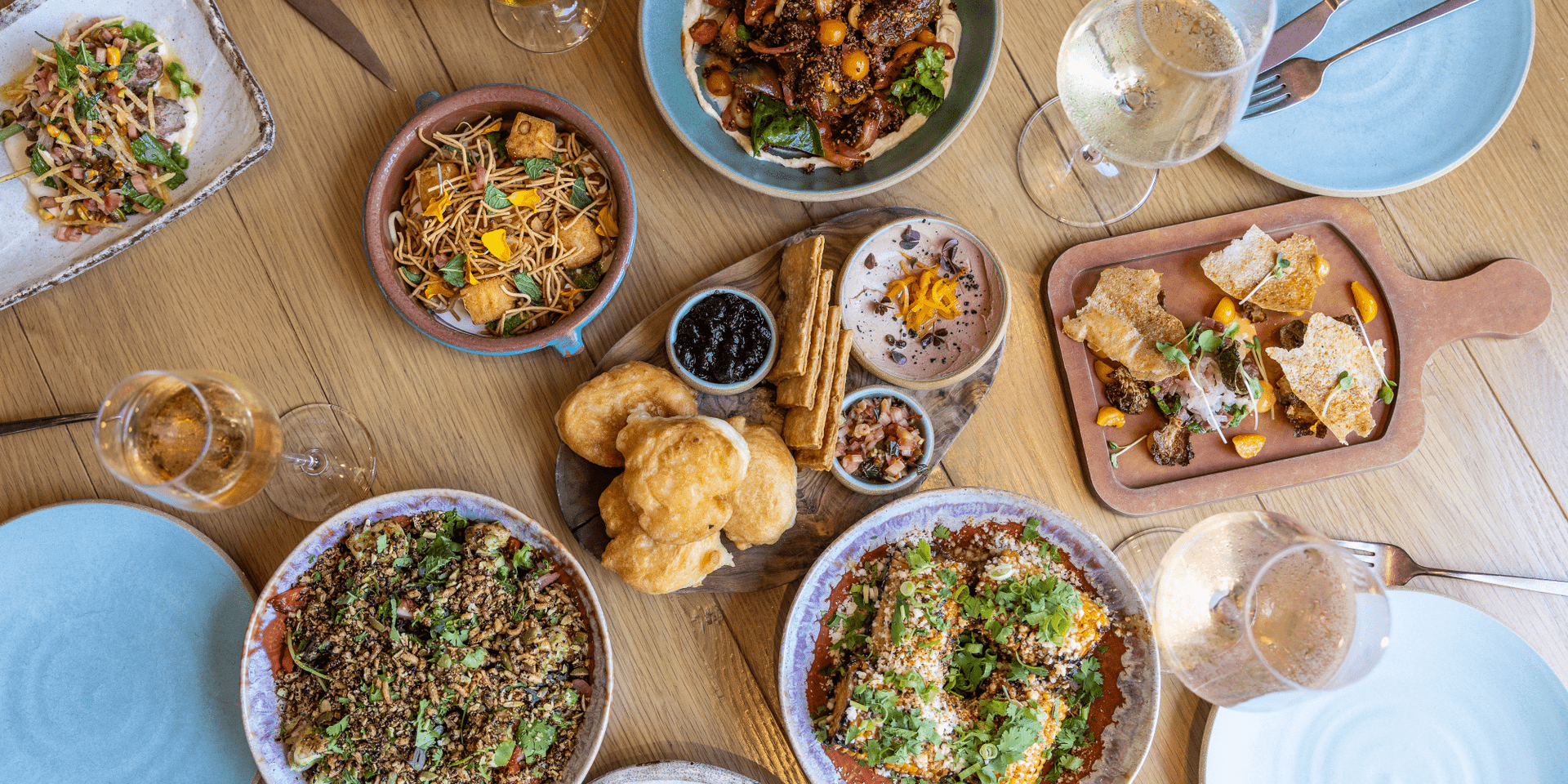 A spread of assorted dishes on a wooden table at Valley Goat restaurant