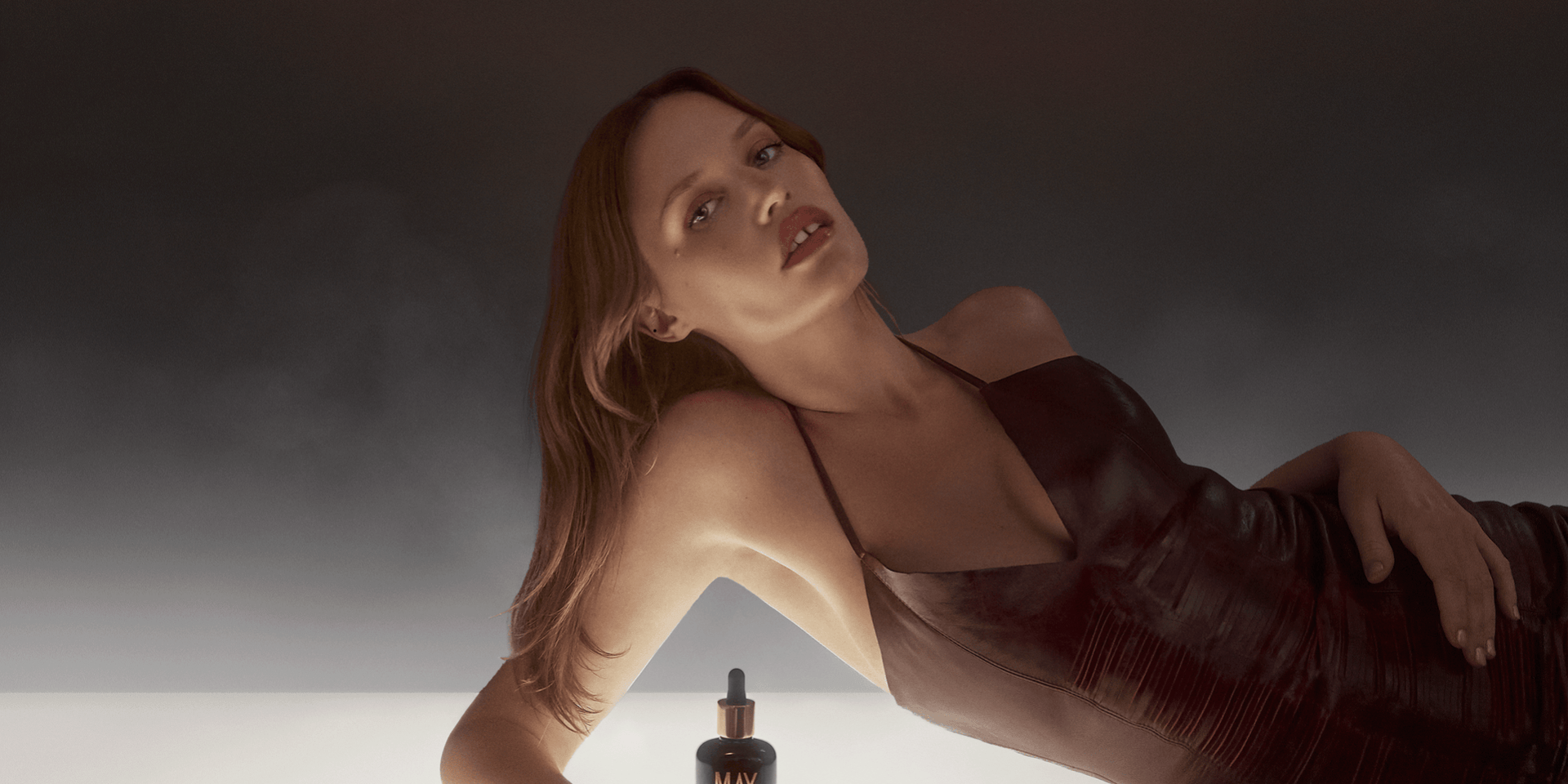 a woman laying down beside a bottle