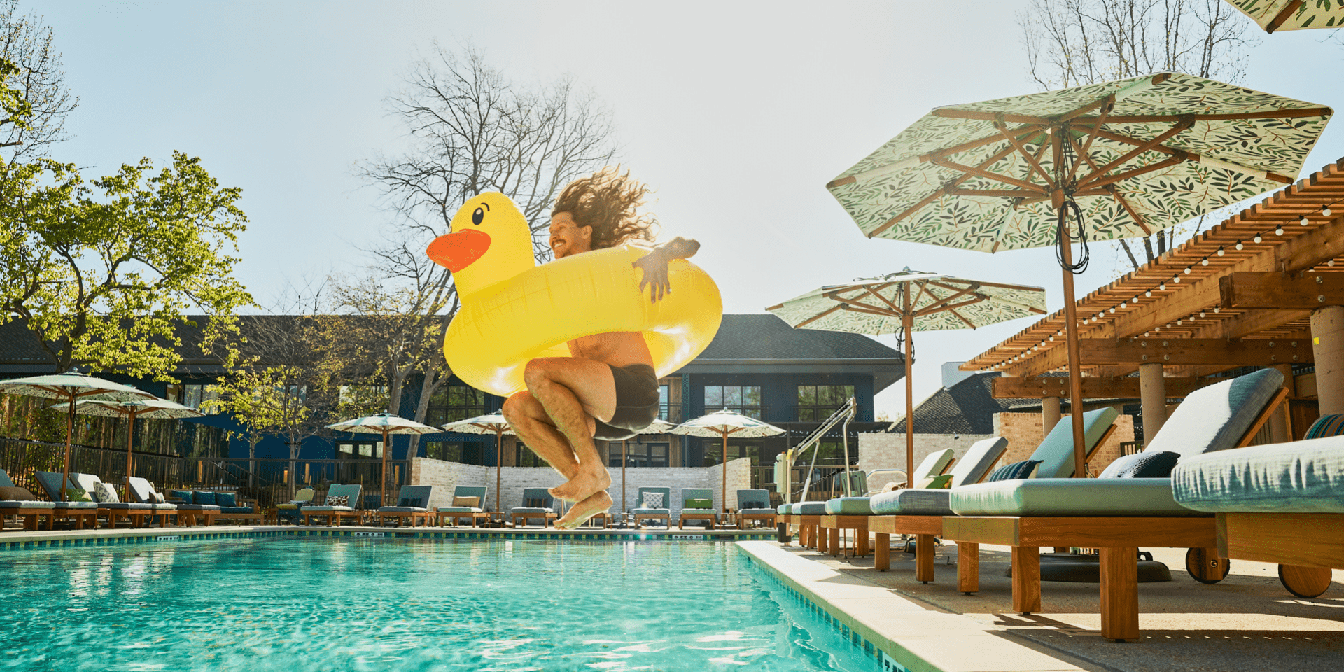 Person jumping into pool with float