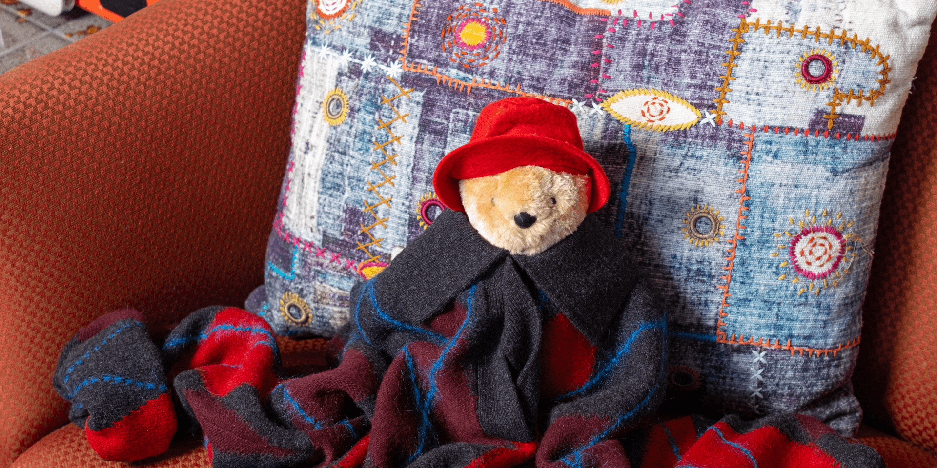 Paddington Bear sitting on an orange chair