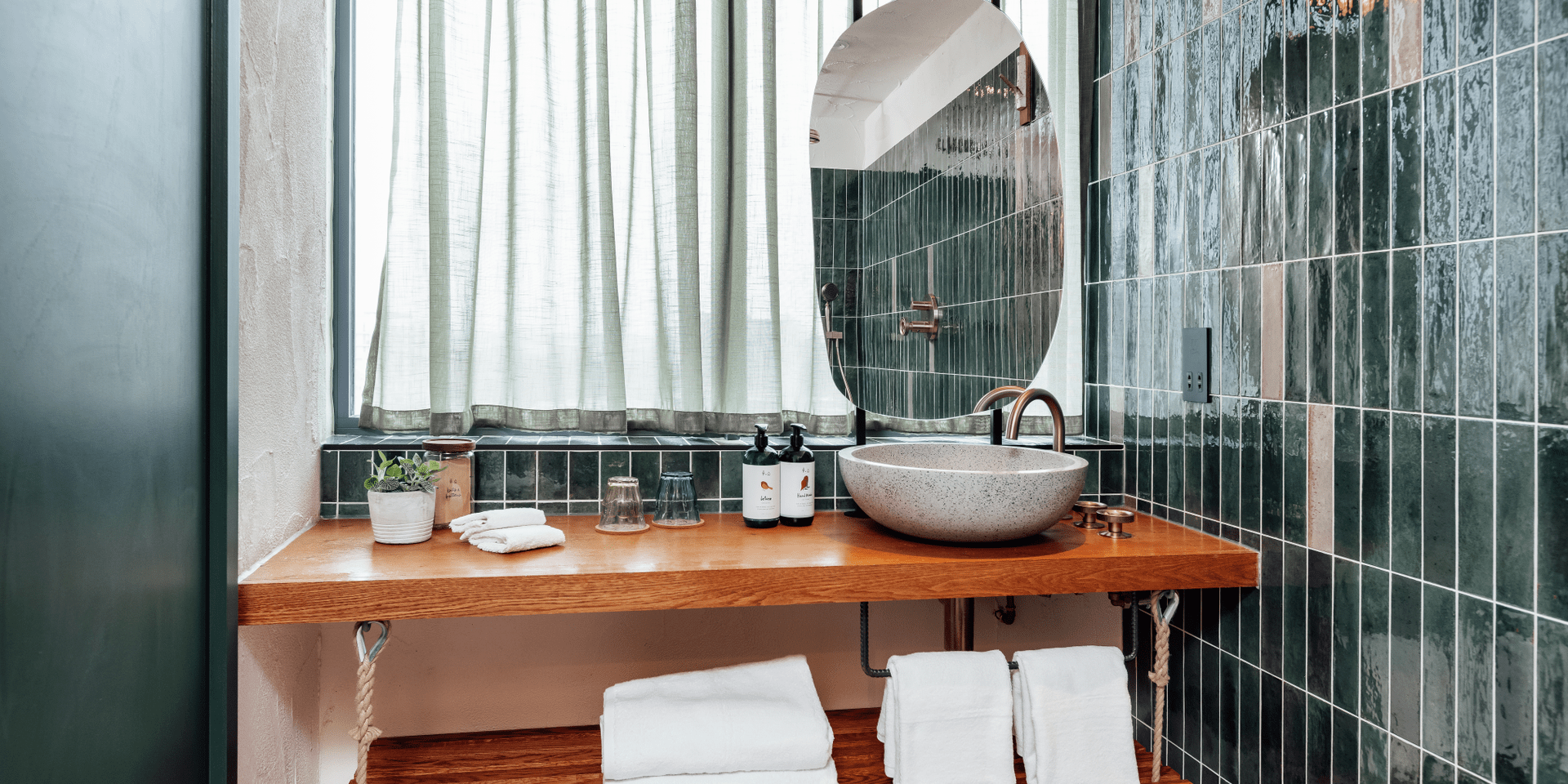 Bathroom with wood vanity and green tile walls