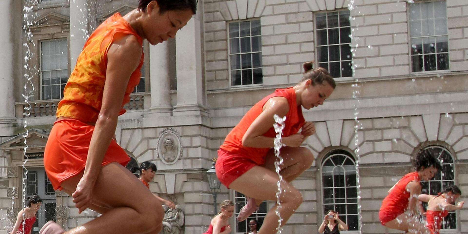 women in orange outfits dancing in water at Somerset House
