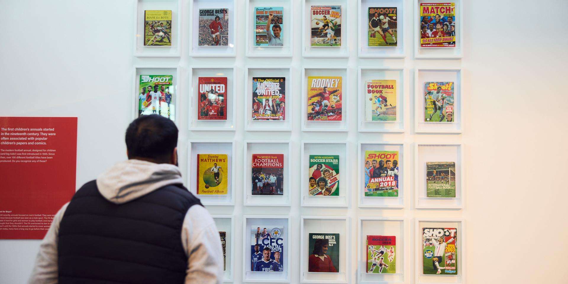 man looking at football magazines