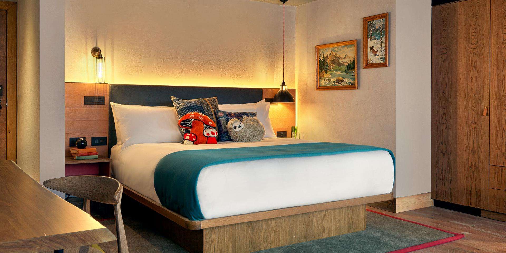 Bed with a sloth and red mushroom pillow 