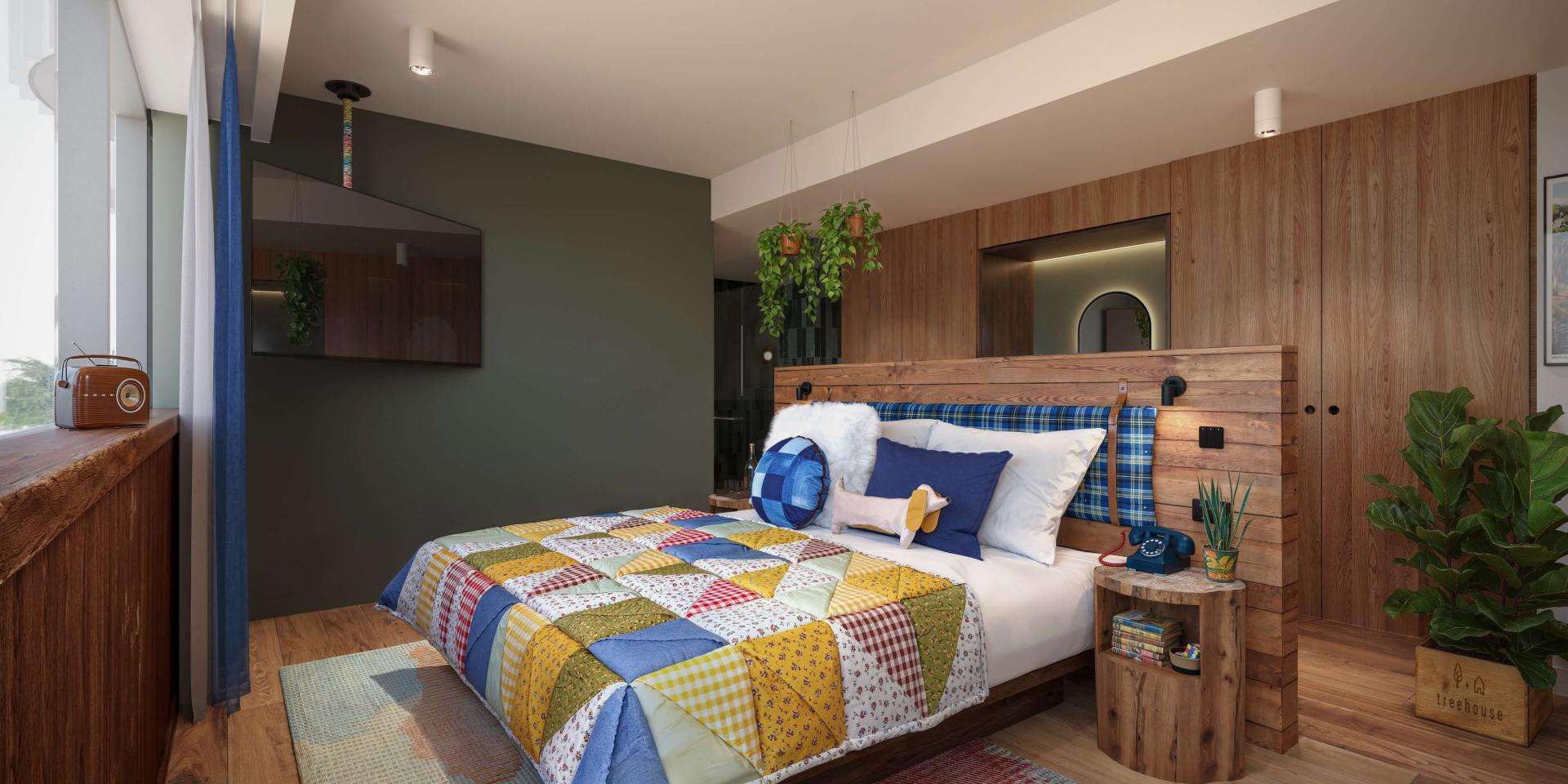 A vibrant bedroom featuring a colorful bedspread and polished wooden flooring.